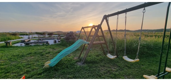 Aire de jeux enfants avec toboggans, balançoires et trampoline.